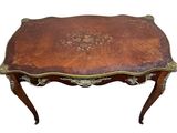 an antique coffee table with a brown leather top and gold trimming