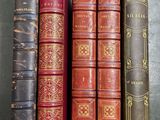 several old books are lined up in a row on a table