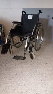 un fauteuil roulant qui se trouve dans une pièce, à côté d'une chaise