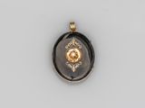 un pendentif doré et noir orné d'un diamant au centre