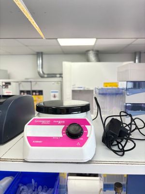 un mixeur rose et blanc posé sur une étagère dans un laboratoire