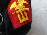 a black jacket with a red and yellow patch on it