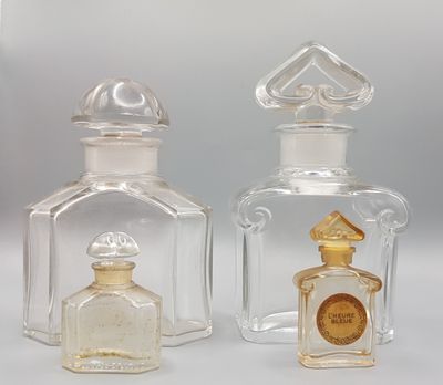 two clear glass bottles with a gold emblem on the top of them
