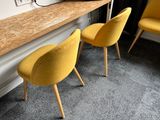 two yellow chairs sitting in front of a wooden desk