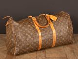 an old louis vuittou bag sitting on a wooden floor