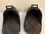 paire de vieilles chaussures en bois sur une surface blanche