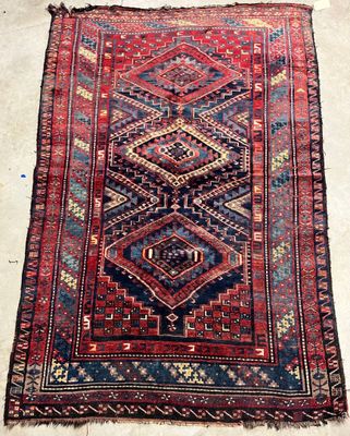 a red and blue rug with a diamond design on it