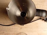 a silver tea kettle sitting on a wooden table next to a glass