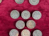 several coins are arranged in a pyramid on a red cloth