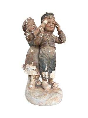 a statue of a boy and a girl on a pedestal