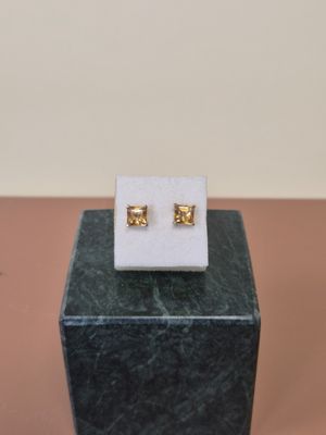 un gros plan sur une paire de boucles d'oreilles posées sur un bloc de marbre