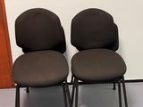 deux chaises de bureau noires placées devant un mur blanc