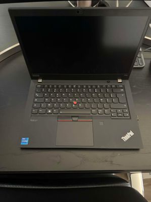 un ordinateur portable posé sur une table, avec un clavier et une souris dessus