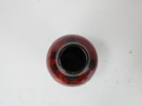 a red vase sitting on a table with a white background