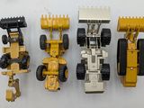 four toy vehicles that are lined up on a table