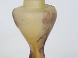 a glass vase with a flower on it on a white surface
