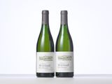 two bottles of white wine sitting on top of a table
