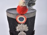 a small hat with a pom pom on top of it