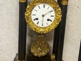 a black and gold clock sitting on a wooden table