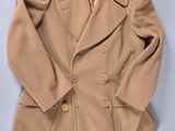 une image représentant un manteau Peale de couleur beige sur fond bleu