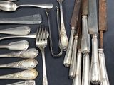 a lot of silver spoons and forks on the table