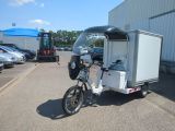 a bike with a trailer attached to it parked in a parking lot