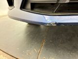 the front bumper of a car with a denting dent on it