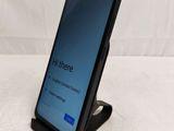 a close up of a phone on a stand on a white surface