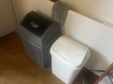 two trash cans and a trash can in the corner of a room