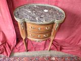 une petite table au plateau en marbre posée sur un tapis