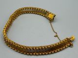 gros plan d'un bracelet en or sur une table
