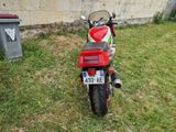 a red and white motorcycle parked in the grass