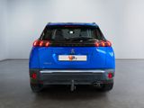 the rear end of a blue car in a white room