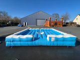 une grande piscine gonflable au milieu d'un parking