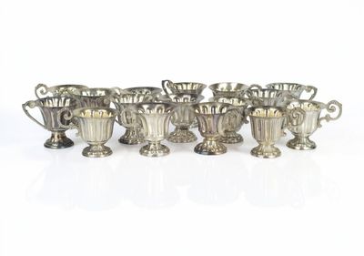 six silver cups are lined up in a row on a white surface