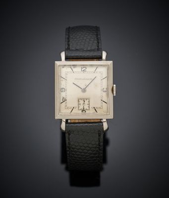 une vieille montre en argent avec un bracelet en cuir noir sur fond noir