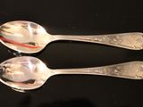 two spoons that are sitting on a table