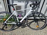un vélo blanc garé à côté d'un immeuble