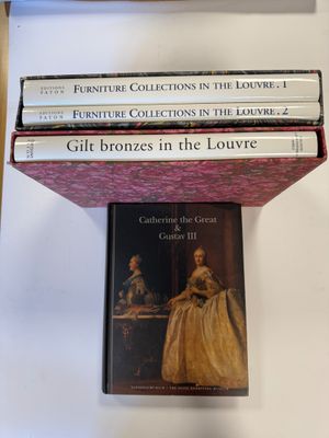 trois livres sont empilés sur une table