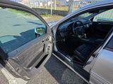 a silver car with its door open on the side of the road