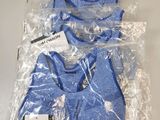 trois paires de t-shirts bleus emballés dans du plastique, posés sur une table