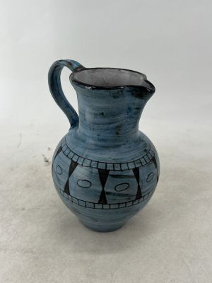 un vase bleu avec une anse noire sur un fond blanc