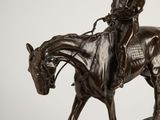 statue of a man riding a horse on a wooden base