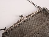 an old silver purse with a chain hanging from it ' s side