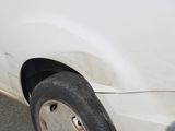 a white car with a flat tire that has a hole in it