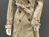 beige trench coat on mannequin mannequin with black leggings