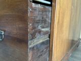 a wooden cabinet with two drawers and a metal handle