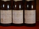 six bottles of wine are lined up on a red table