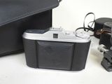 a camera and a bag on a table next to each other