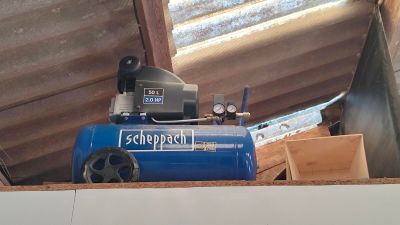 a blue air compressor sitting on top of a wooden box